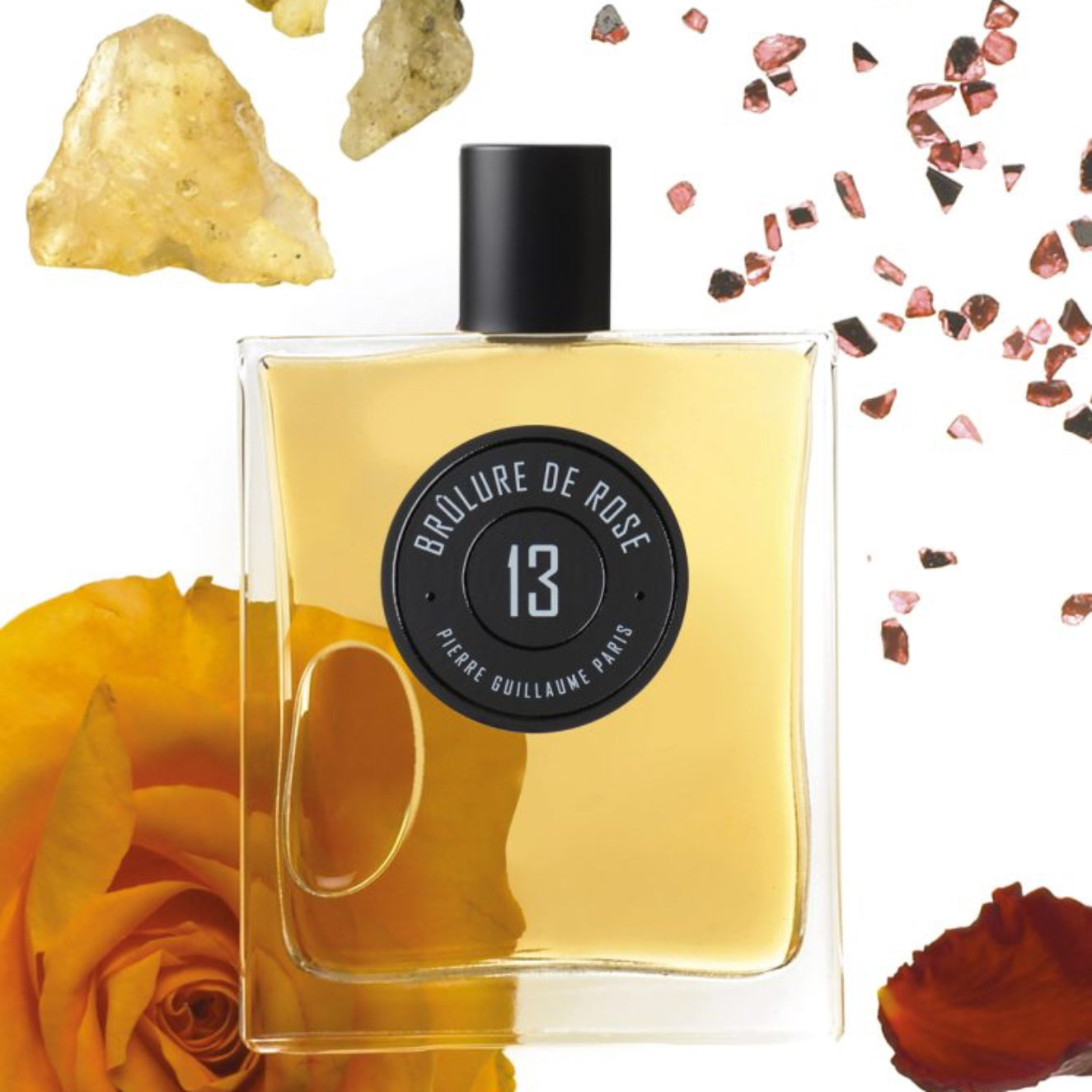 Perfume bottle with rose and rock elements on a white background